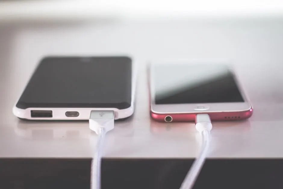 Two smartphones charging side by side on a desk. Modern and technological setting.
